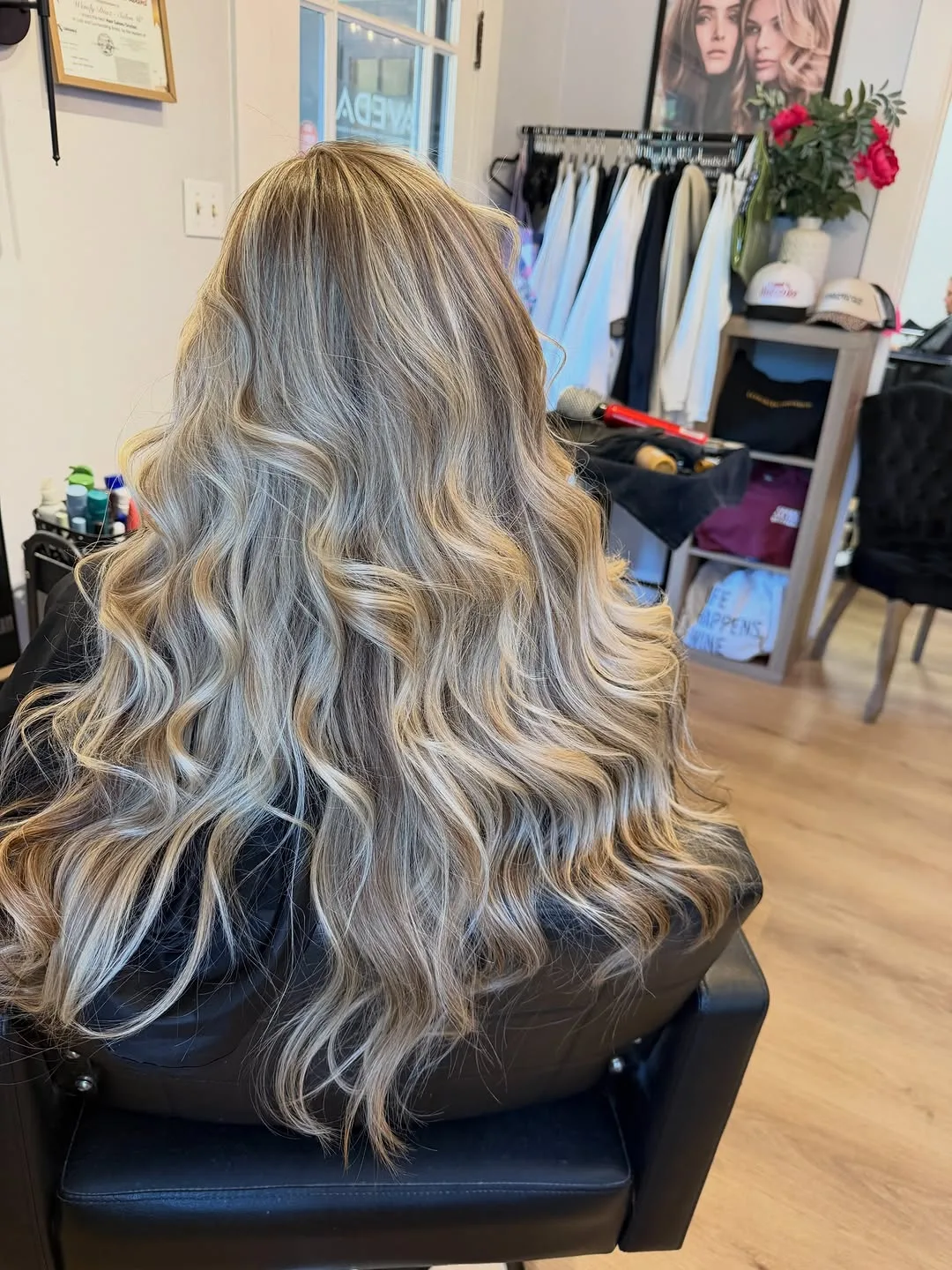 Long blonde balayage with a shadowed root and voluminous waves, photographed from behind at Salon W in Lodi